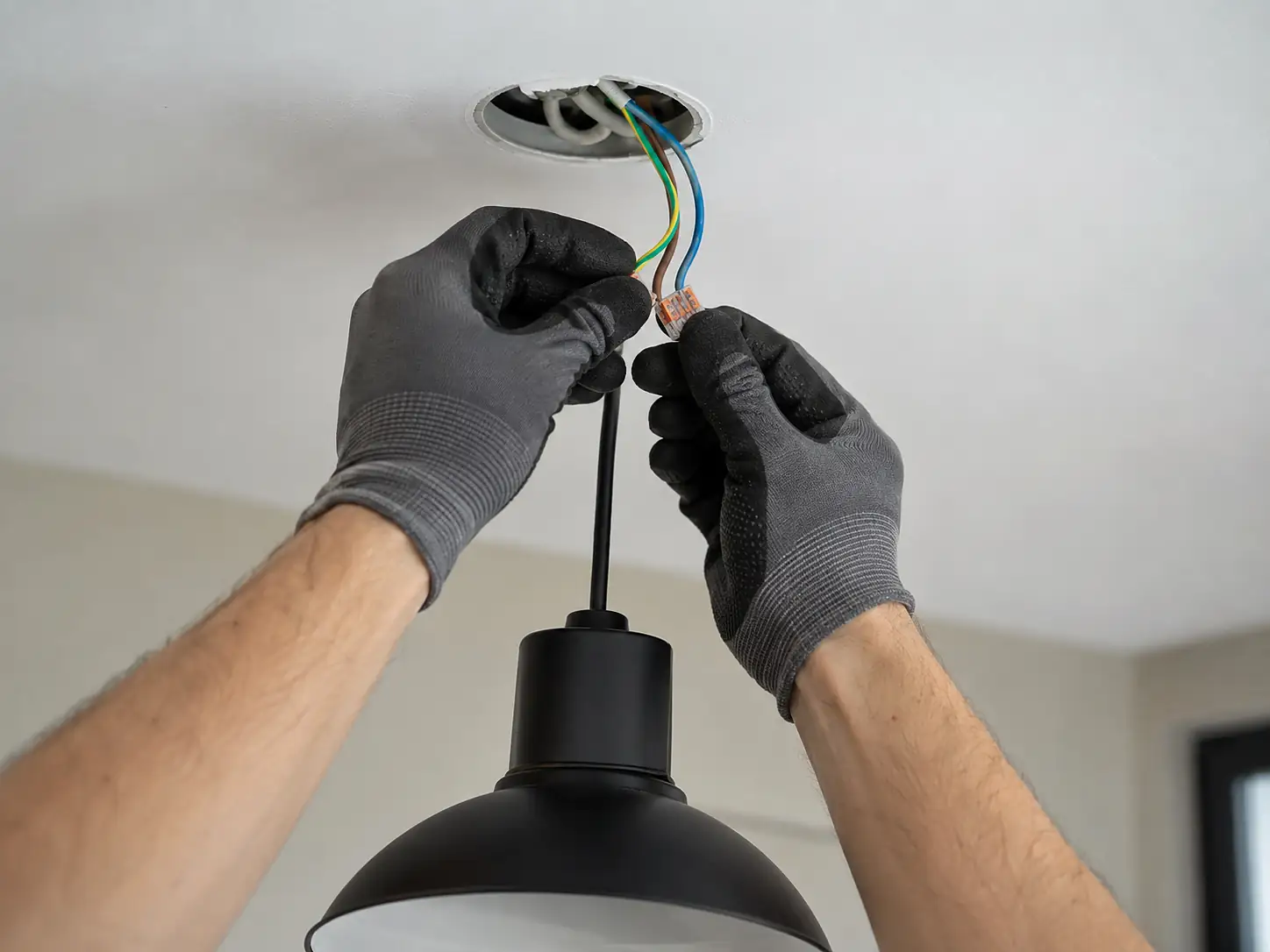 Elektricien sluit de bedrading van een hanglamp aan in Amsterdam